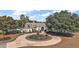 Stately home featuring a circular driveway, lush landscaping, and mature trees offering shade and curb appeal at 1825 Myrtle Lake Ave, Fruitland Park, FL 34731