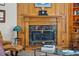 Cozy living space showcasing a wood-paneled fireplace with marble surround, flanked by custom bookshelves at 1825 Myrtle Lake Ave, Fruitland Park, FL 34731