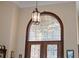 Grand foyer with a statement light fixture and arched transom window above the intricately designed entrance at 1825 Myrtle Lake Ave, Fruitland Park, FL 34731