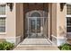 Close-up of front entry featuring tiled porch, arched doorway, and protective screen doors at 1825 Myrtle Lake Ave, Fruitland Park, FL 34731