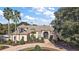 Beautiful front exterior showcasing a circular driveway, well-manicured landscaping and traditional design at 1825 Myrtle Lake Ave, Fruitland Park, FL 34731