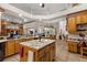 Open kitchen layout featuring an island, wood cabinetry, and granite countertops at 1825 Myrtle Lake Ave, Fruitland Park, FL 34731