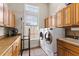 Well-equipped laundry room featuring built-in cabinets, tiled floor, and modern washer and dryer at 1825 Myrtle Lake Ave, Fruitland Park, FL 34731