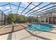 View of backyard screened pool with tanning ledge and fence, complemented by lush landscaping and ample deck space at 1825 Myrtle Lake Ave, Fruitland Park, FL 34731