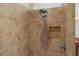 Shower featuring brown tile, shower head, and built-in shelf at 2017 Royal Elm Rd, The Villages, FL 32162