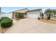 Exterior view of a house with a paved driveway and nicely landscaped front yard at 2222 Southwood Dr, The Villages, FL 32162