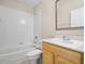 A bright bathroom features a bath tub shower combination, a toilet, and a wooden vanity at 225 Sutherland Ct, Apopka, FL 32712