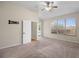 Bright bedroom with neutral carpet, ceiling fan, and a doorway leading to the bathroom at 225 Sutherland Ct, Apopka, FL 32712