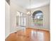 Dining area featuring gleaming wood floors, a chandelier, and a large arched window at 225 Sutherland Ct, Apopka, FL 32712