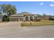 Charming home featuring a three-car garage, arched windows, and a neatly landscaped front yard at 225 Sutherland Ct, Apopka, FL 32712