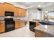 Well-lit kitchen with stainless steel appliances, granite countertops, and wooden cabinets at 225 Sutherland Ct, Apopka, FL 32712