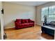 Living room with red couch and hardwood floors at 225 Sutherland Ct, Apopka, FL 32712