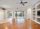 Open living room featuring wood floors, sliding glass doors, and custom built-in shelving at 225 Sutherland Ct, Apopka, FL 32712