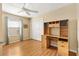 This bedroom features a ceiling fan, wood floors, a built-in desk and a double closet at 2303 Nehaul Ter, The Villages, FL 32162