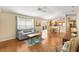 Bright living room with a view of the kitchen and dining area, featuring wood floors at 2303 Nehaul Ter, The Villages, FL 32162