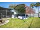 Wide view of backyard including screened lanai and car port with car under cover at 2384 Orange Capital Ct, Eustis, FL 32726