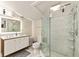 Modern bathroom featuring a double sink vanity, glass shower, and white tiled floors and walls at 2384 Orange Capital Ct, Eustis, FL 32726