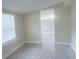 Bright room with neutral walls and flooring features a window bringing in natural light, next to an open doorway at 2384 Orange Capital Ct, Eustis, FL 32726