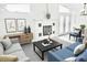 Bright living room features a decorative fireplace, light gray sofas, and stylish decor for comfortable and inviting space at 2384 Orange Capital Ct, Eustis, FL 32726