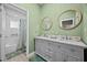 Bathroom featuring dual sinks, green walls, and a shower/tub combo at 24429 Adair Ave, Sorrento, FL 32776