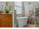 Bright bathroom featuring a freestanding tub with marble tile accent wall and natural light at 24429 Adair Ave, Sorrento, FL 32776