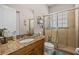 Bathroom featuring a granite countertop vanity, a glass-enclosed shower, and neutral tile at 24429 Adair Ave, Sorrento, FL 32776