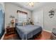 Bedroom with blue comforter on bed, lamps on side tables, and double door closet at 24429 Adair Ave, Sorrento, FL 32776