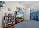 Bedroom featuring a TV and a bookcase with personal items and blue accent wall at 24429 Adair Ave, Sorrento, FL 32776