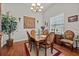 Formal dining room with elegant chandelier, hardwood floors, and ample seating, ideal for hosting gatherings at 24429 Adair Ave, Sorrento, FL 32776