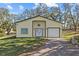 Charming exterior view of the home with well-maintained lawn, garage, and white doors at 24429 Adair Ave, Sorrento, FL 32776