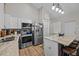 Modern kitchen featuring stainless steel appliances, granite countertops, and stylish white cabinets at 24429 Adair Ave, Sorrento, FL 32776