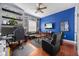 Living Room features hardwood flooring, a large-screen television, and a ceiling fan at 24429 Adair Ave, Sorrento, FL 32776