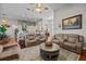 Spacious living room featuring hardwood floors, a ceiling fan, a stone accent wall, and comfortable seating arrangements at 24429 Adair Ave, Sorrento, FL 32776