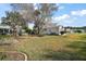 Large grassy backyard with mature trees and a partially visible home at 25324 Hibiscus St, Leesburg, FL 34748