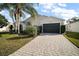 One story house with light siding, dark garage door and landscaping at 25324 Hibiscus St, Leesburg, FL 34748