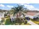 One-story house with white siding, dark garage door, and palm trees at 25324 Hibiscus St, Leesburg, FL 34748