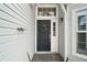 Dark green front door entry with a paved walkway at 25324 Hibiscus St, Leesburg, FL 34748