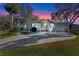 Charming home exterior with well-maintained lawn, driveway, carport and lush landscaping at 25547 Belle Helene, Leesburg, FL 34748