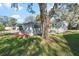 Side yard shows lush grass, large tree, small flower beds and privacy at 25547 Belle Helene, Leesburg, FL 34748
