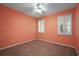 Well-lit bedroom with ceiling fan and coral walls at 27008 Camerons Run, Leesburg, FL 34748