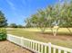 Landscaped backyard with a white fence and golf course view at 2849 Leicester Ter, The Villages, FL 32162