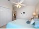 Light and airy bedroom with a queen-size bed, ceiling fan, and double doors leading to a closet at 2849 Leicester Ter, The Villages, FL 32162