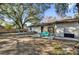 Spacious backyard with patio furniture under large oak trees at 307 Park Ave, Groveland, FL 34736