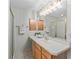 Bright bathroom has a large vanity mirror, bright lighting, and a walk-in shower at 3183 Hatch Ln, The Villages, FL 32162