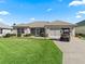 Charming one-story home with well-kept lawn and golf cart parked in the driveway at 3183 Hatch Ln, The Villages, FL 32162