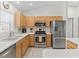 Well-lit kitchen with stainless steel appliances and light wood cabinetry at 3183 Hatch Ln, The Villages, FL 32162