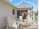 Covered patio area with glass table and chairs, perfect for outdoor dining and relaxation at 3183 Hatch Ln, The Villages, FL 32162