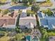 Aerial view displays the screened patio, mature trees, and manicured backyard of the home, nestled between neighboring houses at 3319 Thorncrest Dr, The Villages, FL 32162