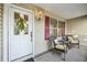 Charming front porch features a white front door, decorative wreath, seating, and red shutters at 3319 Thorncrest Dr, The Villages, FL 32162