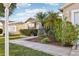 Landscaped front yard with healthy green lawn and shrubbery, walkway to a home with tan siding at 3319 Thorncrest Dr, The Villages, FL 32162